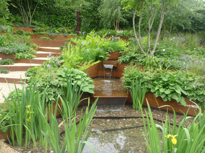 Corten steel used to terrace the garden and channel water to a pool below